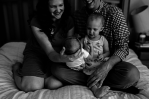Family looking upon their newborn baby.