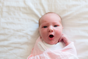 Newborn baby girl on simple white background.